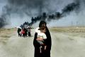 НИДРИНГХАУС, Аня. Иракская женщина с ребенком покидает Басру. 2003 г. 